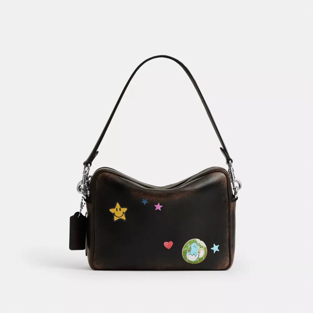 Bolso bandolera Dakota del 10.º aniversario de Rexy en piel desgastada con estampado de pegatinas