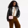 Bolso bandolera Mini Carey en Signature Canvas con Charms