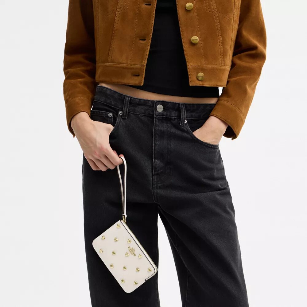 Bolso de pulsera con cremallera en la esquina y remaches en forma de corazón