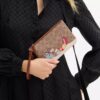 Bolso de pulsera pequeño «Essential» en Signature Canvas con regalos navideños