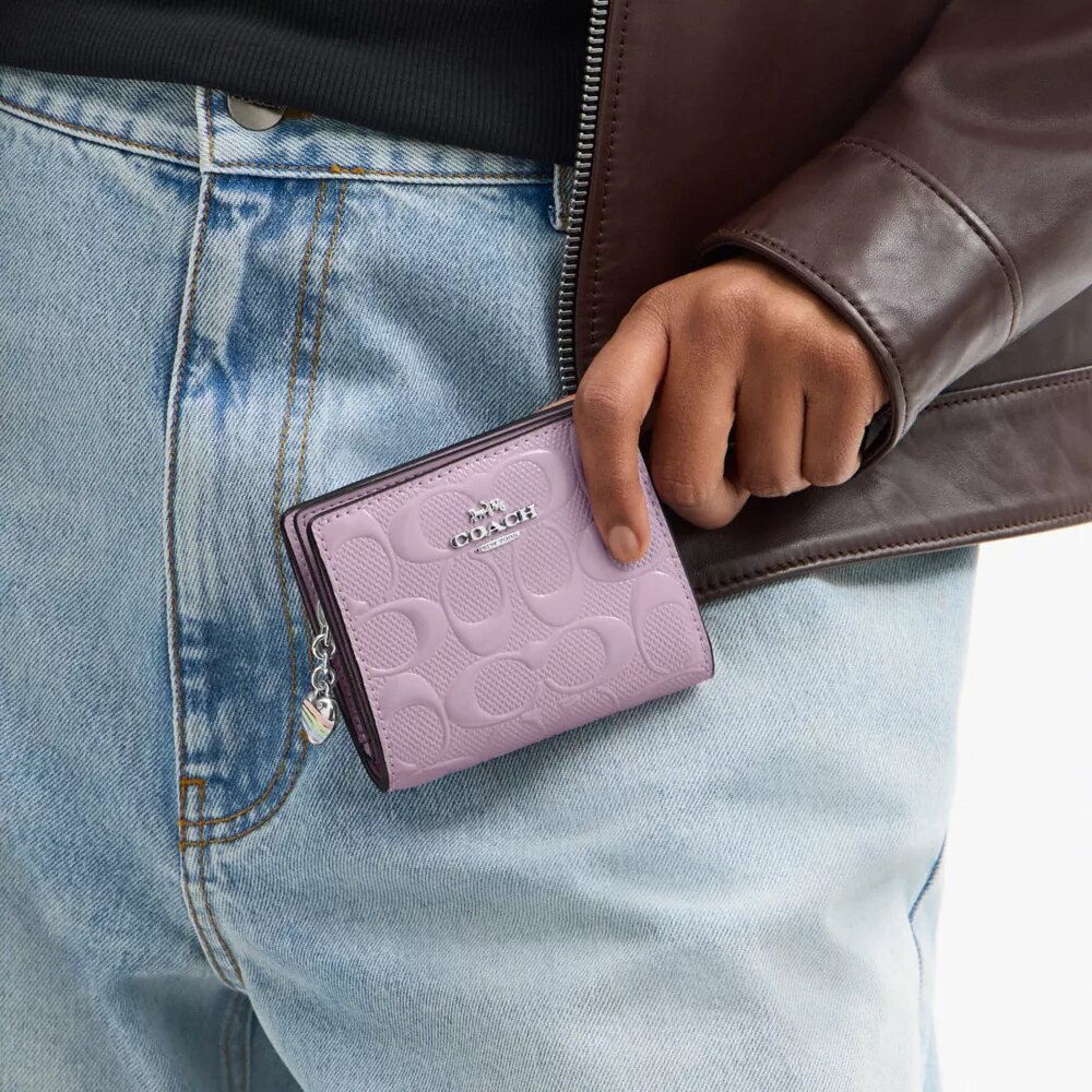 Cartera con cierre a presión de cuero exclusivo y colgante en forma de corazón