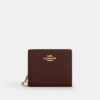 Cartera con cierre a presión y Charms