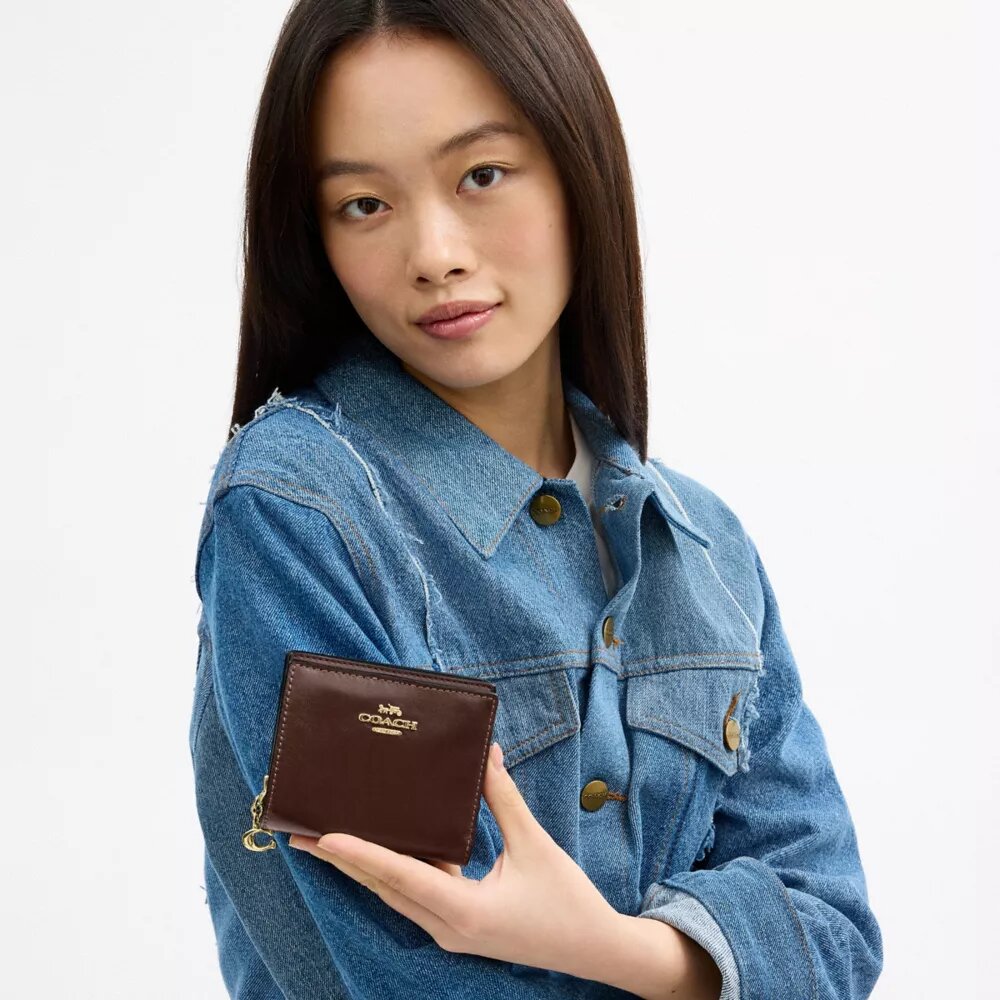 Cartera con cierre a presión y Charms