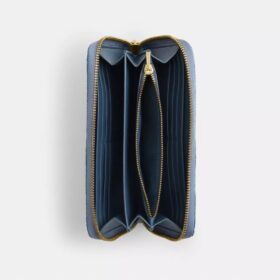 Cartera larga con cremallera perimetral en denim desgastado