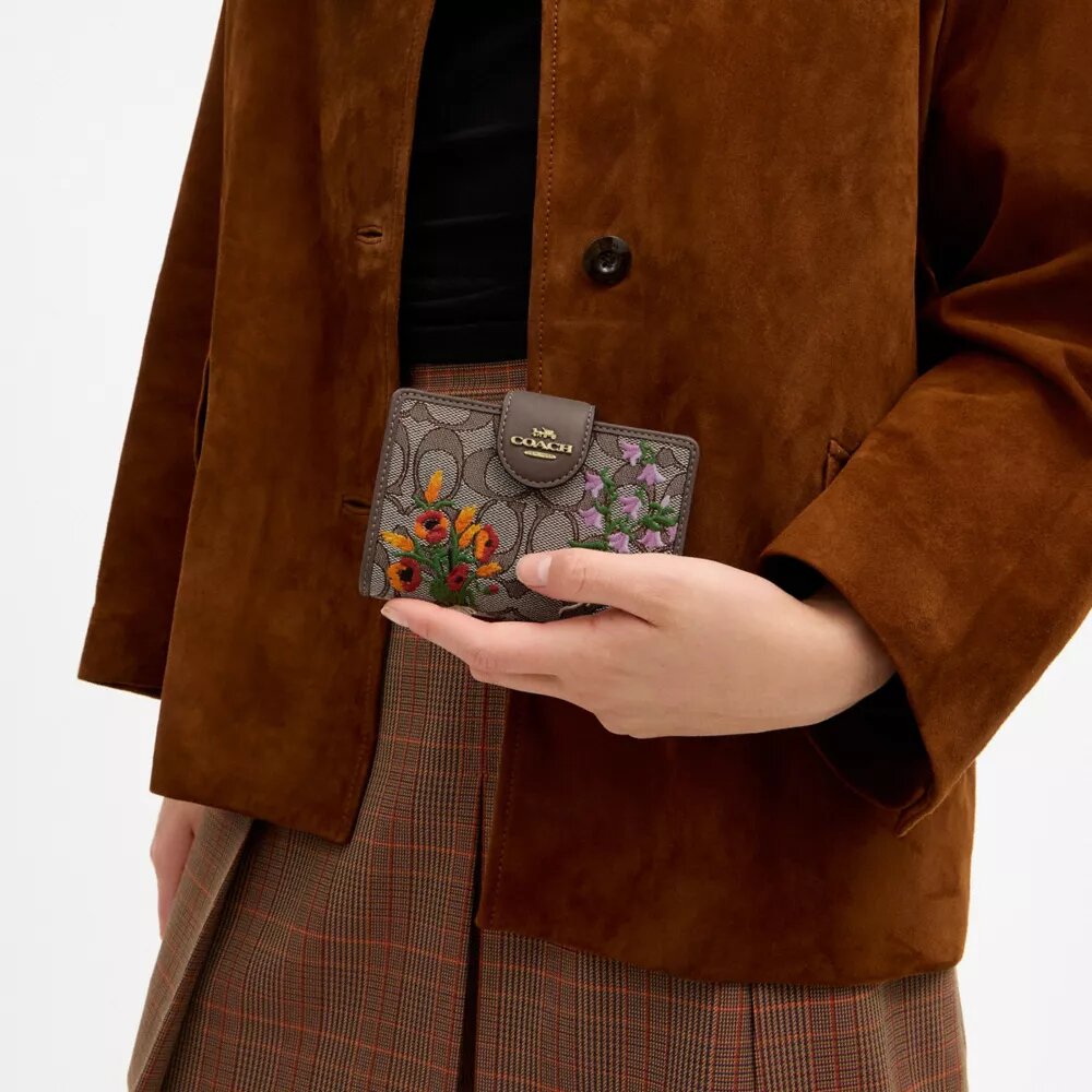 Cartera mediana con cremallera en las esquinas, en jacquard exclusivo con bordado floral